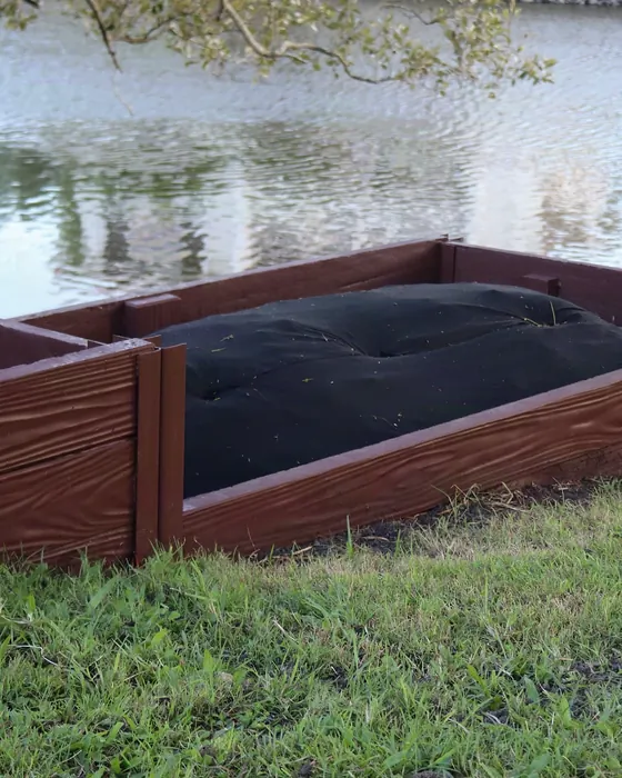 Raised garden beds built from antique-timber Hybrid Sleepers beside a canal